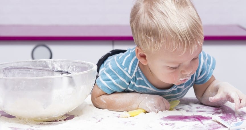 Exploratory Play | Launch Your Child's Exploration-little boy playing in spilled flour in the kitchen