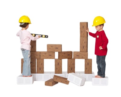 jumbo blocks - two preschoolers building a fort with the giant blocks wearing yellow hard hats