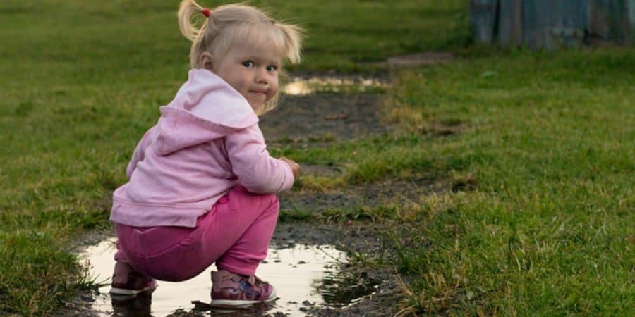 constructive play-outdoors-young girl playing the mud