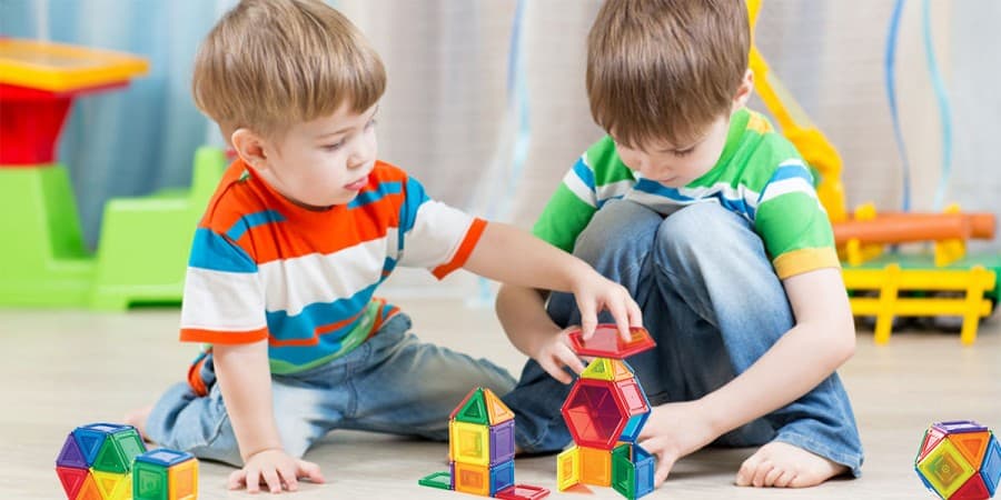 what are social skills-two young brothers playing with magnetic tiles