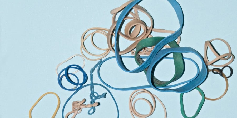 fine motor activities for preschoolers-rubber band fine motor activities-pile of blue, green and tan rubber bands in a variety of sizes