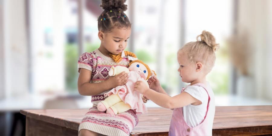 social emotional activities for preschoolers-two young girls caring for a doll