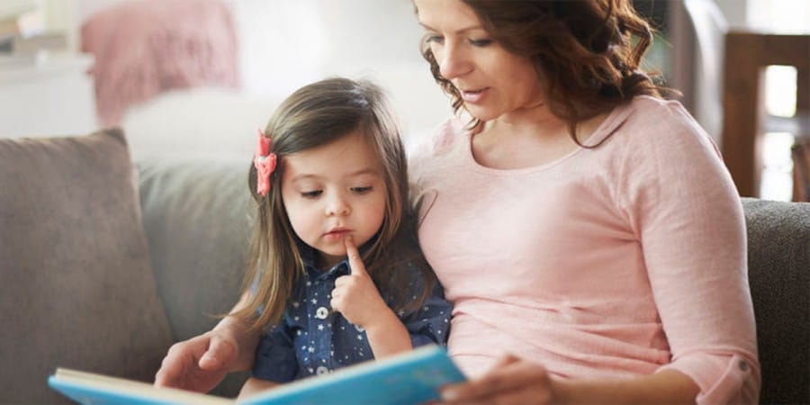 language development- mother and young daughter reading a book together
