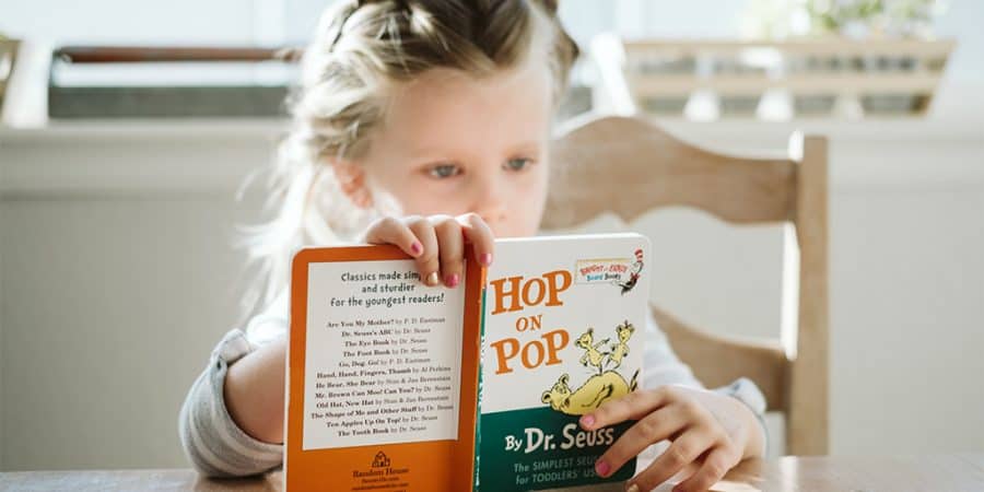 screen time alternatives-young girl reading a Dr. Seuss book