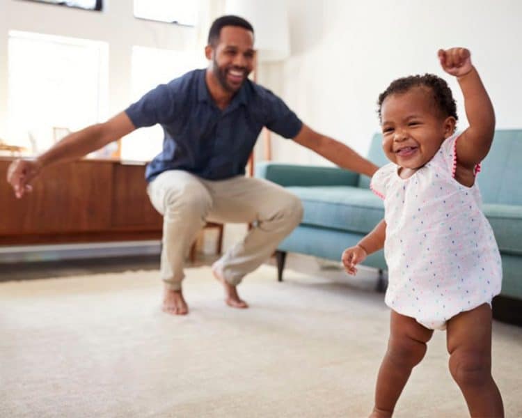 indoor activities for toddlers-musical activities-young toddler girl and father enjoying a dance party in the living room