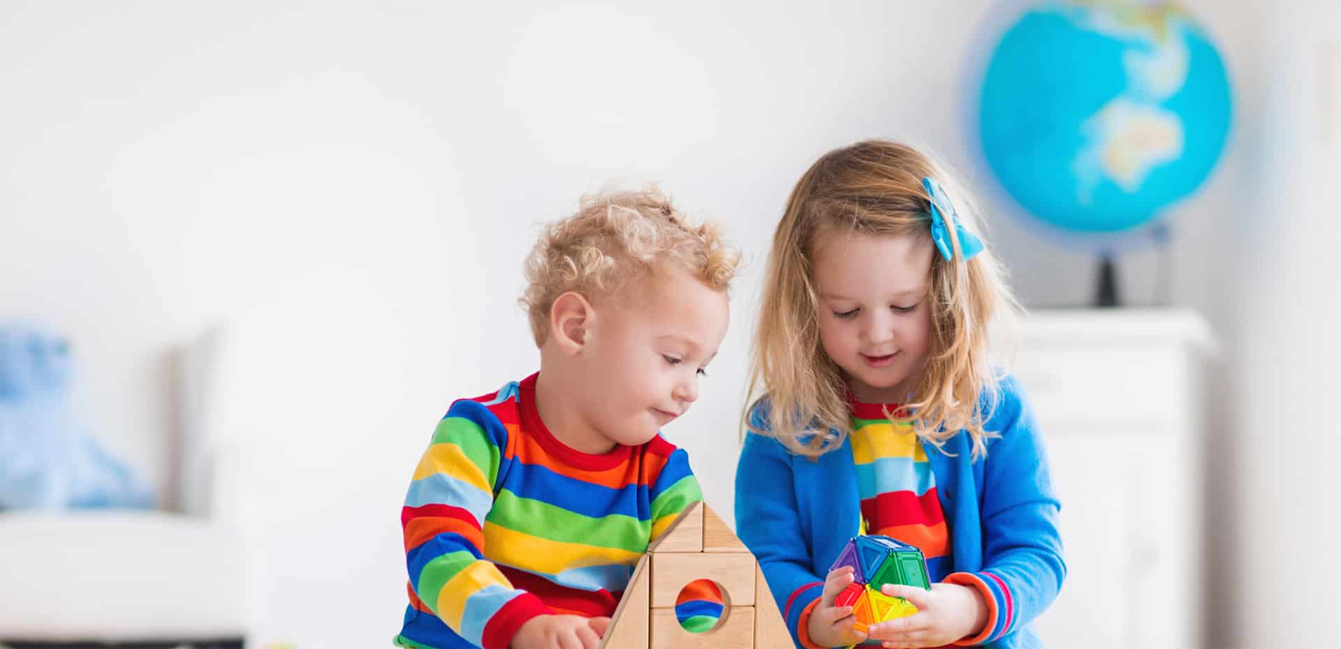 brother and sister playing with building sets and blocks including natural wooden blocks and colorful magnetic blocks