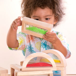 playing with blocks - young boy engaged in blocks play and stacking colorful wooden building blocks