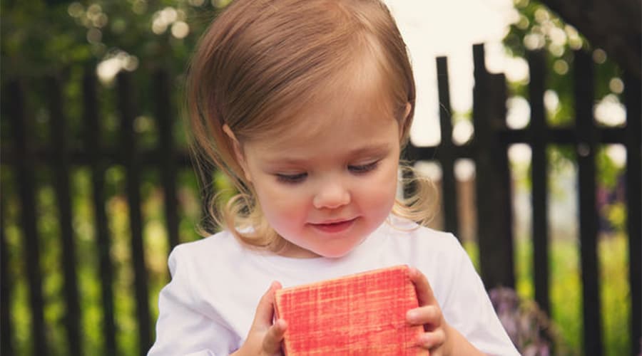 block play-toddler girl playing with a large red blocks