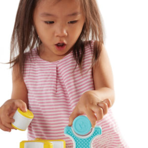 early childhood development - young Asian girl stacking magnetic blocks